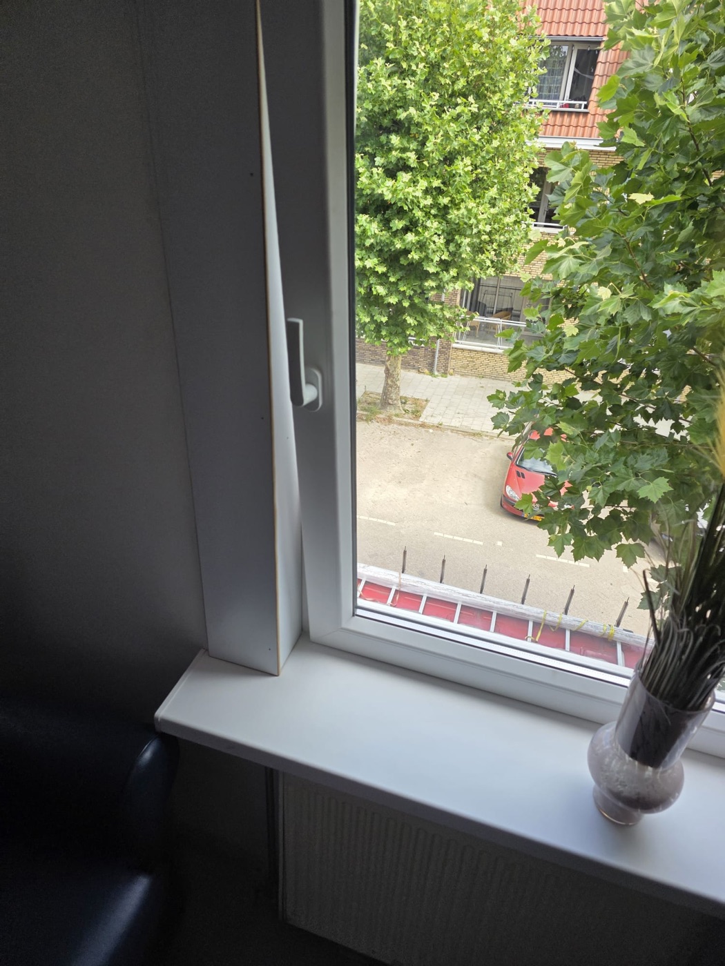 Wit kunststof draaikiepraam met zicht op straat
